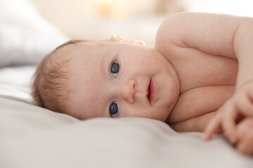 Cute newborn baby lying on bed, closeup