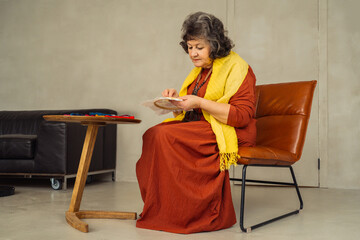 Senior woman engaged in creative activity inside a homey setting