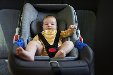 Cute little baby fastened in car seat
