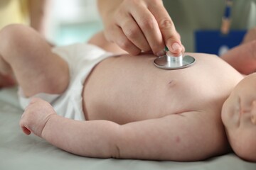 Mother and her cute little child having appointment with pediatrician in hospital. Doctor examining...