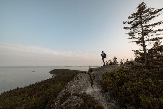 Female hiker stands on summit of Gorham Mountain, Acadia National Park