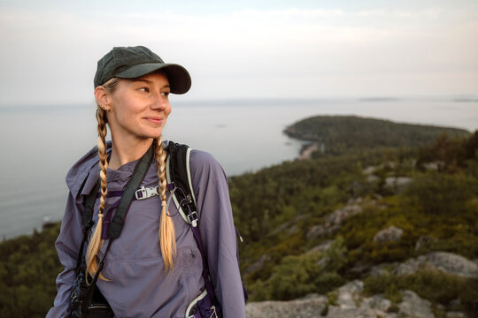 Smiling female hiker with baseball hat and pigtails, Maine
