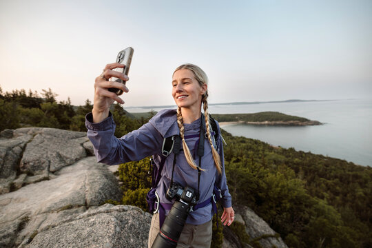 Female hiker takes selfie with cell phone, Acadia National Park