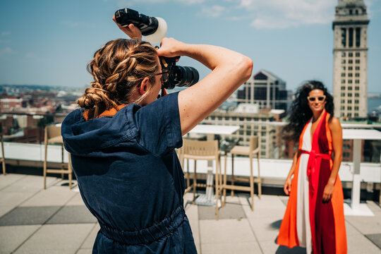 Photographer captures model in red dress on sunny Boston rooftop