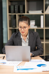 Fototapeta premium Asian businesswoman working on laptop at office