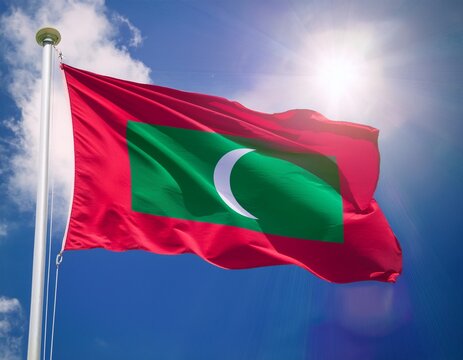 maldives flag waving with sun shines brightly behind; blue sky background
