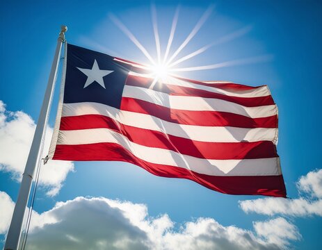 liberia flag waving with sun shines brightly behind; blue sky background
