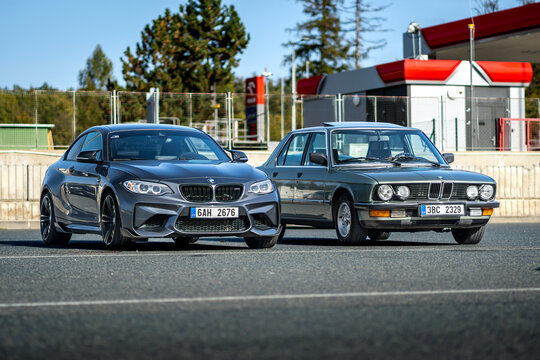 New and old BMW M luxury car parked next to each other outside in a parking lot. Fast sports cars made in Germany.