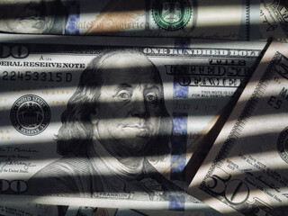The shadow of the blinds resembles the grid on dollar bills with Benjamin Franklin. The concept of...