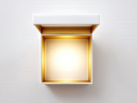 Open luxury gift box with glowing golden light.  Minimal white and gold box with glowing light from inside, viewed from above