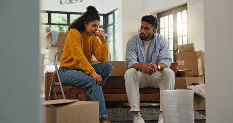 Frustrated couple, argument and conflict with boxes in new home for relocation or disagreement....