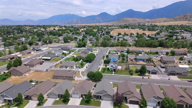 Aerial footage showcases a charming USA suburban neighborhood with majestic mountains, making it ideal for real estate listings and scenic projects, valuable for buyers and investors
