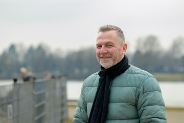 Smiling Man Near Waterfront Fence
