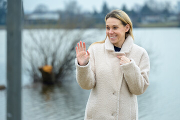 Smiling Woman Waves By Lake