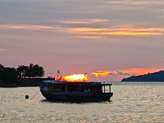 Fishing Boat at Tropical Snset with Sillhoueted Palm Trees