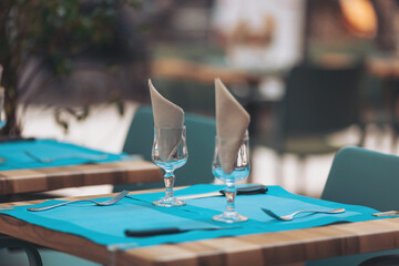 Elegant dining setup with turquoise decor invites guests to experience a memorable culinary evening at an outdoor restaurant in vibrant spring atmosphere
