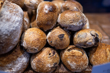 Artisanal bread rolls stacked together showing crusty exterior and flour dusting, traditional European bakery close-up on wooden surface, fresh baked goods