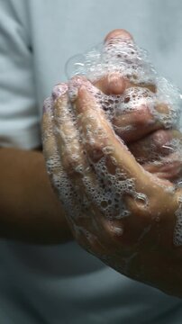 A man without a face washes his hands with anti-inflammatory soap after going outside to prevent the spread of bacteria and germs.
Clean hands during a pandemic.
hygiene and care