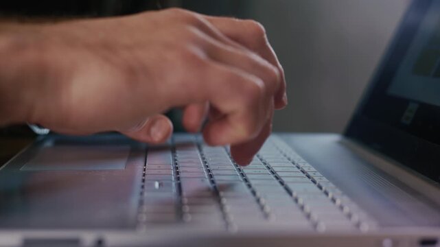 Programmer writing code on laptop keyboard