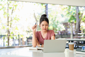 Focused asian girl student pupil writing notes in notebook distance learning studying online doing homework college school education, elearning concept.