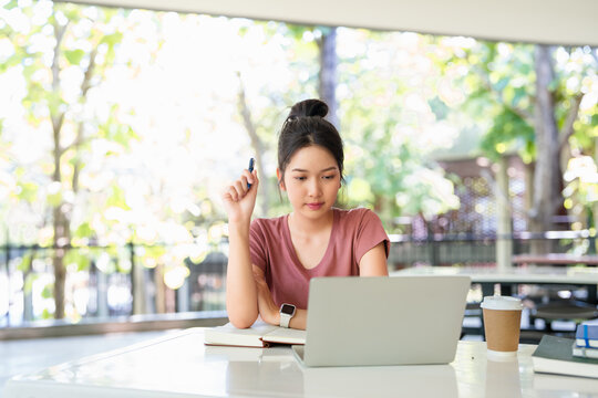 Focused asian girl student pupil writing notes in notebook distance learning studying online doing homework college school education, elearning concept.
