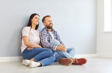Happy peaceful young couple cozy on floor resting at own house at relocation day, bank loan and...