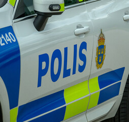 A distinctive police vehicle is parked on the street, showcasing its bright color scheme and official markings. The vehicle stands ready for any law enforcement duties in the city