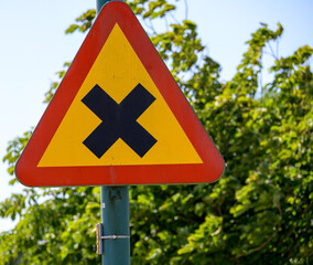 A caution sign placed on a street pole alerts pedestrians and drivers to intersection ahead. The...