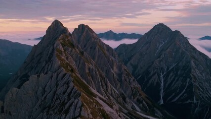 4K panoramic footage of mountain peaks at sunrise with golden light and drifting fog, showcasing the vastness and serenity of nature. - Powered by Adobe