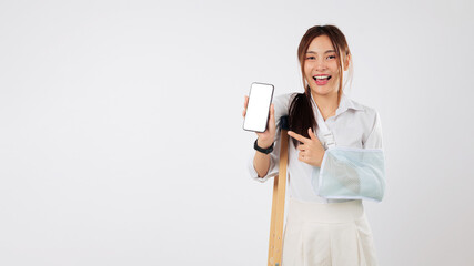 Asian woman with broken arm in plaster point mobile phone screen for support after accident, still...