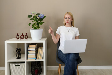 Woman with laptop giving thumbs up while working from home