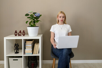 Focused woman using laptop in minimalist home office