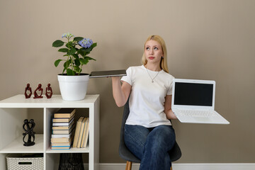 Woman weighing options between tablet and laptop in home office