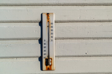 weathered old thermometer on building wall outdoors