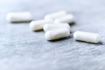 Beta-alanine capsules. Bodybuilding food supplements on wooden background. Soft focus. Close up....
