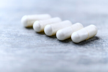 Beta-alanine capsules. Bodybuilding food supplements on wooden background. Soft focus. Close up....