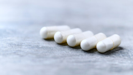 Beta-alanine capsules. Bodybuilding food supplements on wooden background. Soft focus. Close up....