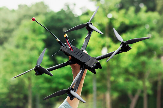 Drone War. Drone in Hand on Green Nature Background. Drone for the War. Volunteering for Drones.