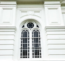 Architectural elegance captured a symmetrical white window with decorative grilles and moldings