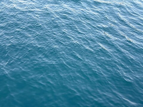 Blue water rippling calm surface background.