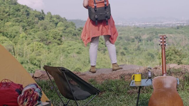 Asian woman camping alone with tent on summer holiday. Outdoor activity and lifestyle.