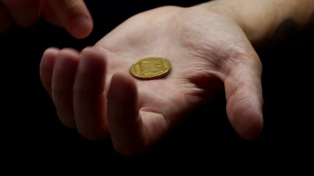 Financial savings and money concept.
Mathelic coin and cent in hands on a black background close-up.
Penny in a man's hand.
A man holds a cent in his hands.
Cents and coins