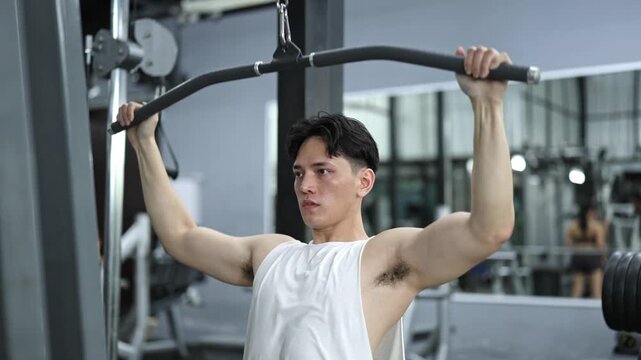 Young athlete performing lat pulldowns in gym