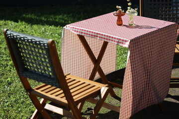 A simple dining setting with a vase of fresh flowers, ideal for an intimate dinner or special occasion