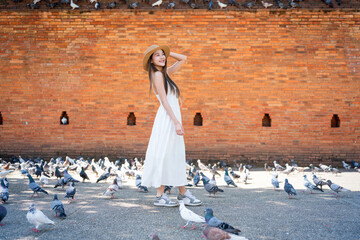 Asian tourist woman enjoying travel moments at Tha Phae Gate, Chiang Mai. Young woman in white...