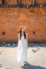 Asian tourist woman walking near Tha Phae Gate in Chiang Mai. Young woman in white dress exploring...