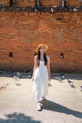 Asian tourist woman walking near Tha Phae Gate in Chiang Mai. Young woman in white dress exploring...