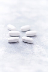 Amino acids tablets on wooden background. Soft focus. Close up	