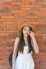 Asian tourist woman walking near Tha Phae Gate in Chiang Mai. Young woman in white dress exploring...