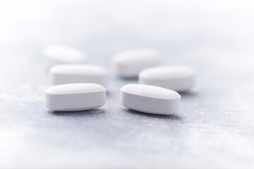 Amino acids tablets on wooden background. Soft focus. Close up	